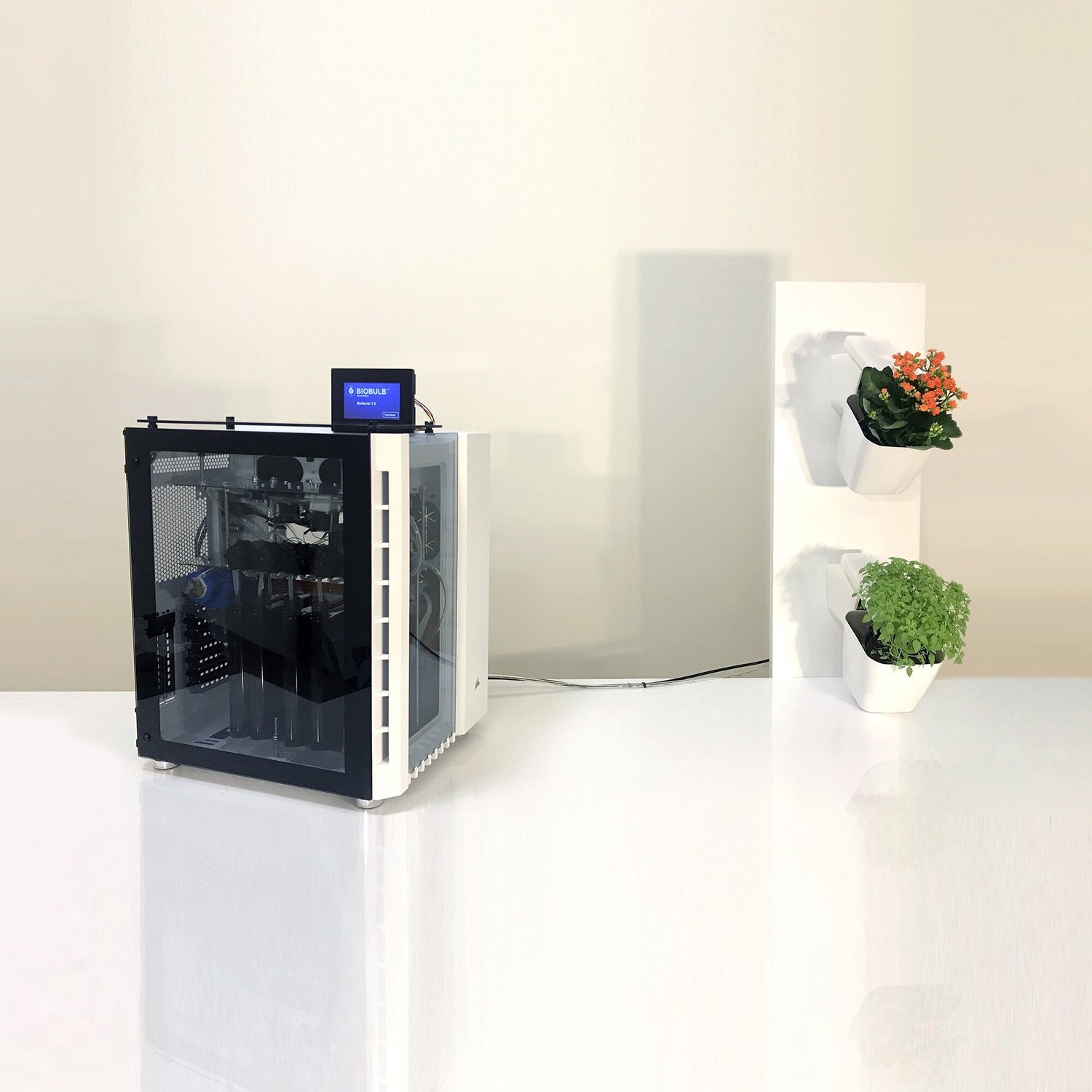 The desktop control and growth unit beside a modular plant tower
